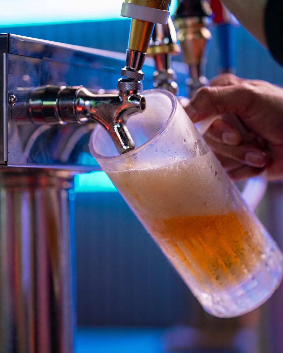 A frosted mug being filled with draft beer at the SKYBOX tap