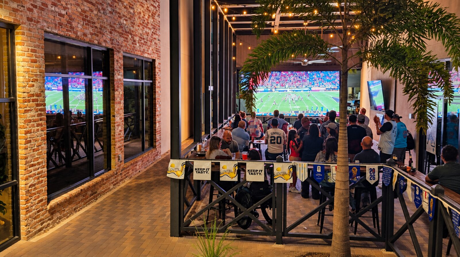 The patio at night — big screen under the string lights